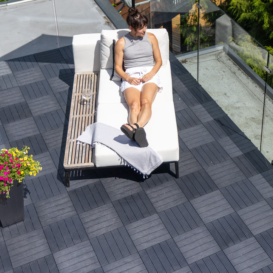Person sitting on a lounge chair on interlocking deck tiles