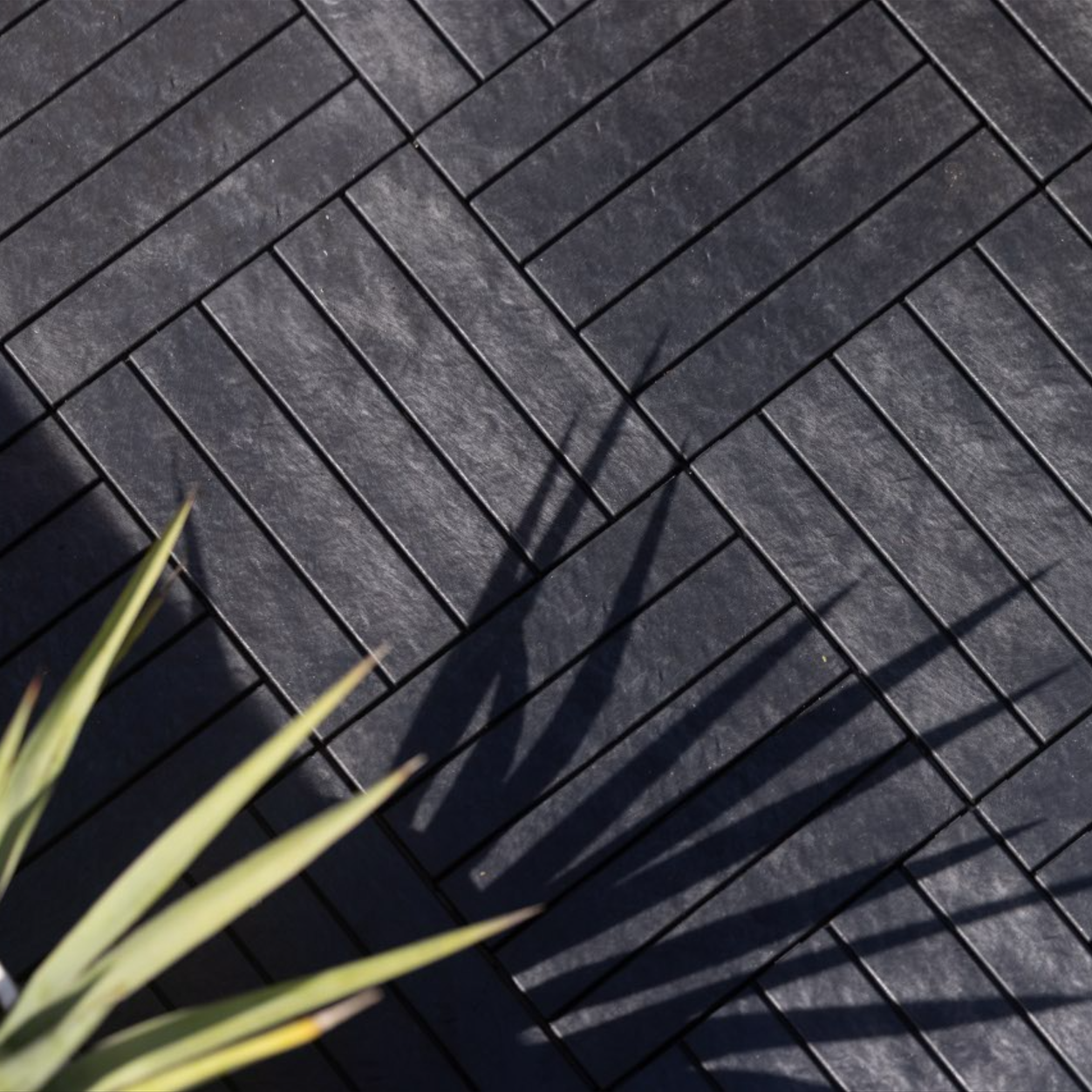 Black natural stone interlocking deck tiles that are clean and contemporary