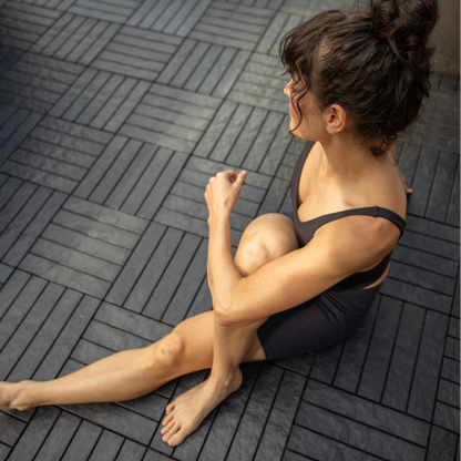 woman sitting on interlocking deck tiles that are modern