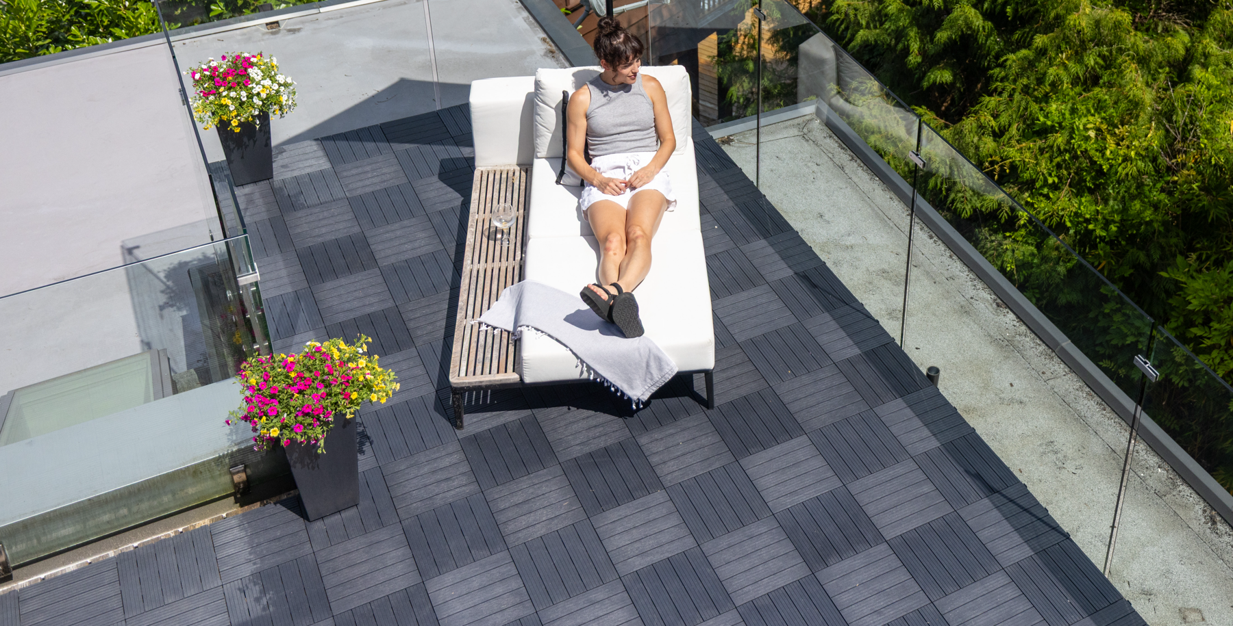 Person sitting on a lounge chair on interlocking deck tiles